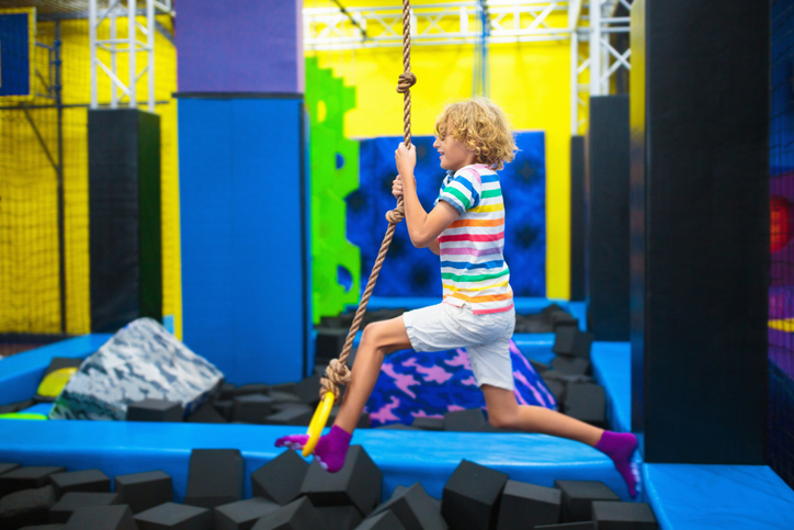 Child jumping in trampoline park. Bounce fun.