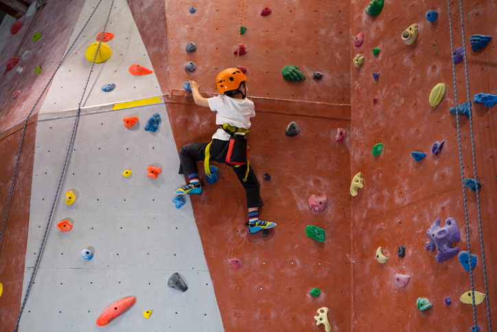 Determined boy practicing rock climbing